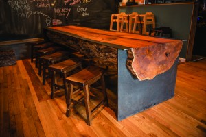 Pictured is a CP Furniture log table and benches installed at Grain Craft Bar + Kitchen on Main Street, Newark. (Photo by Carlos Alejandro)