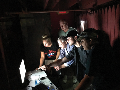 Alicia Lenoir, Mike Little, Andy Lendway (standing), Kyle McMahon and Fred Conkey watch the cameras set up at Frightland on a monitor at the central command center. Photo courtesy of the Diamond State Ghost Investigators (DSGI)