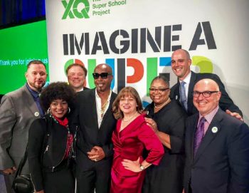 Cristina Alvarez (in red) and the Delaware Design Lab team receiving the XQ Super School award for educational innovation and excellence from famed rapper MC Hammer. (Photo courtesy of The Design Lab High School)